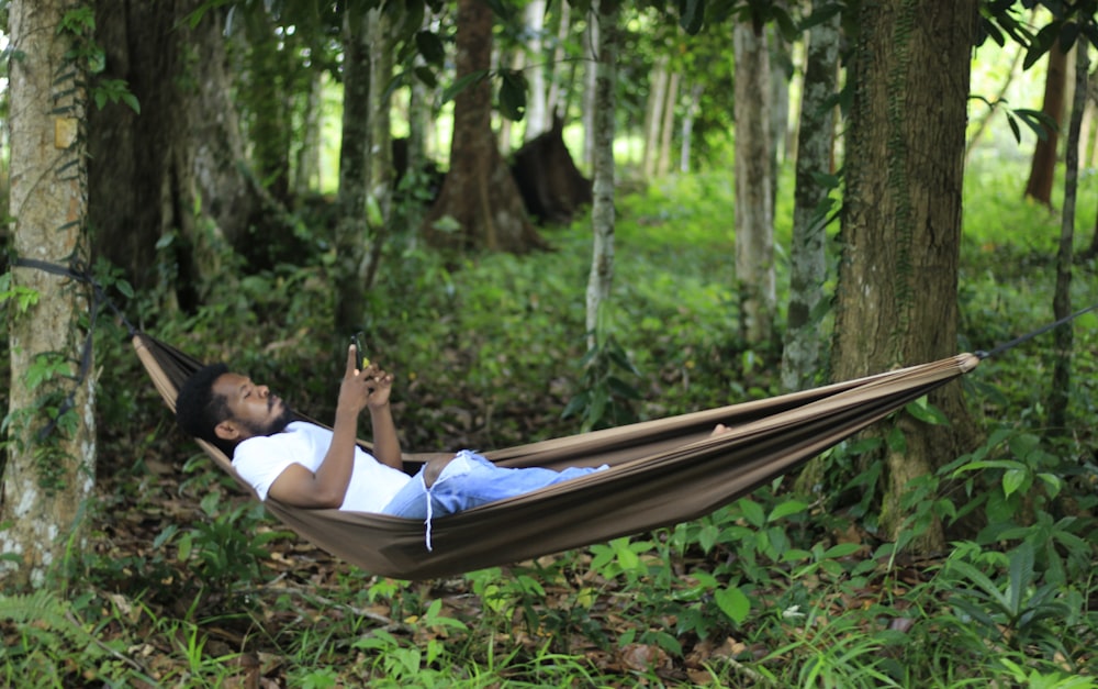 woman in white shirt lying on hammock