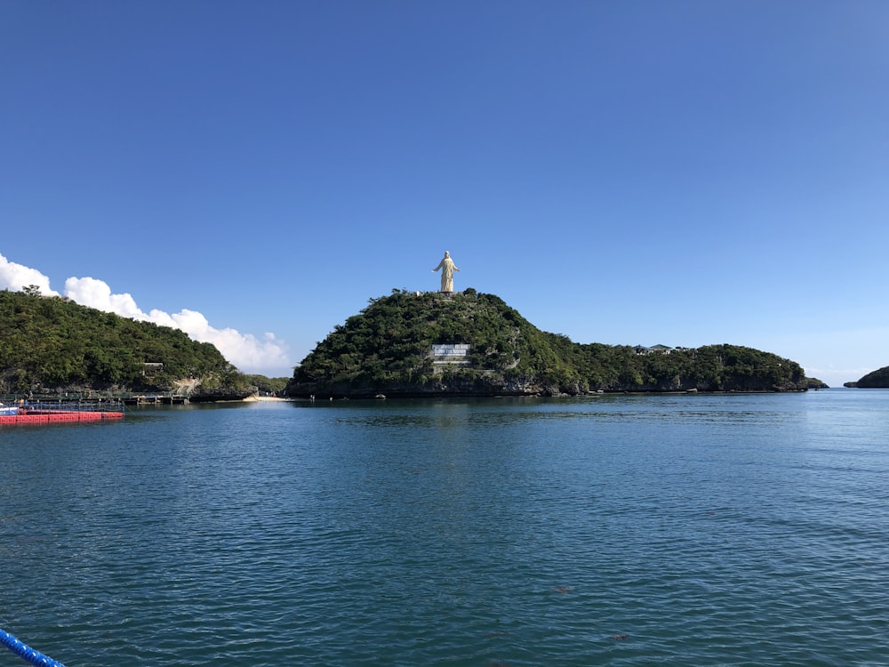 brown and white concrete building on island surrounded by green trees under blue sky during daytime