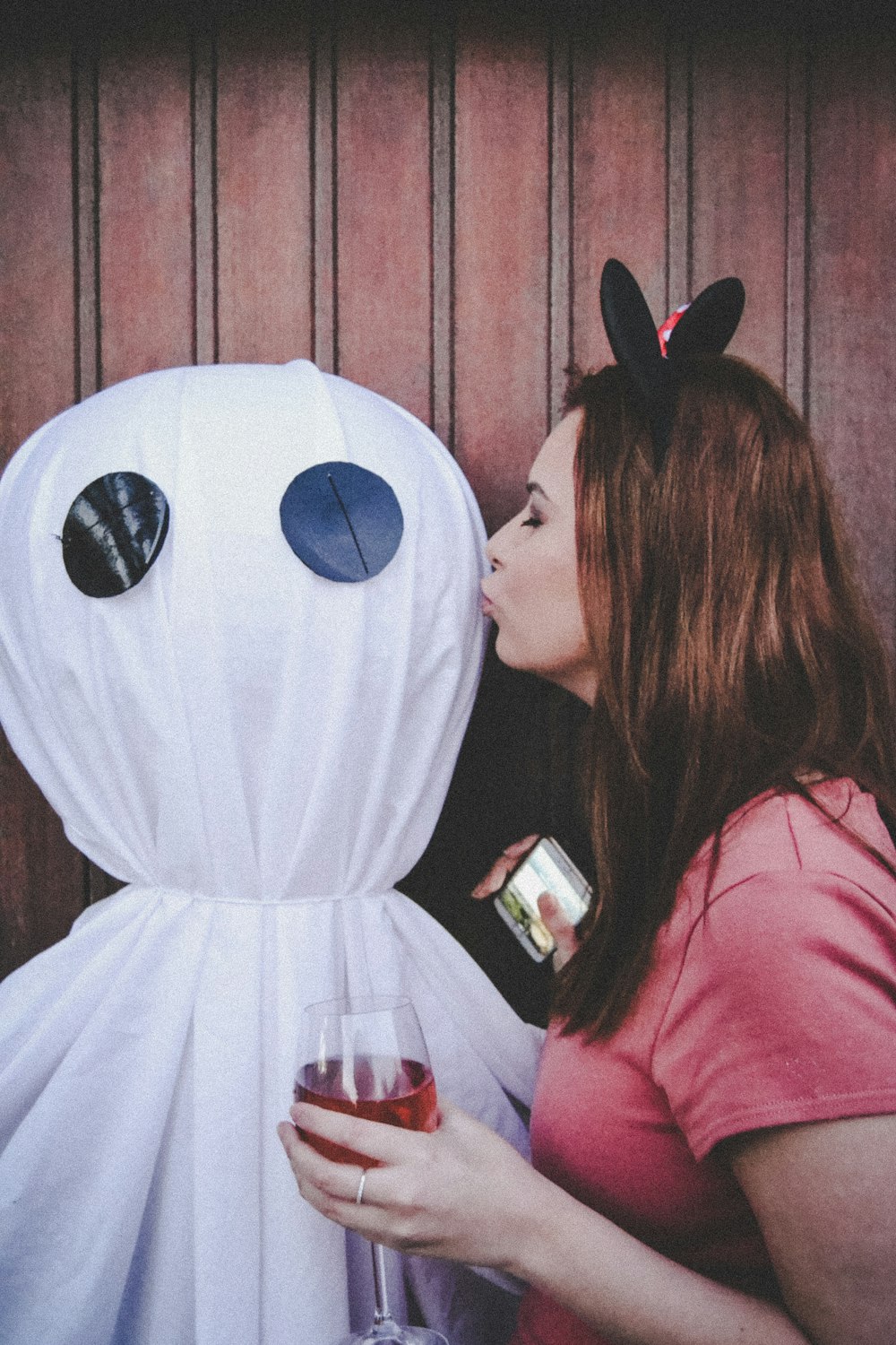 woman in pink long sleeve shirt holding white smartphone