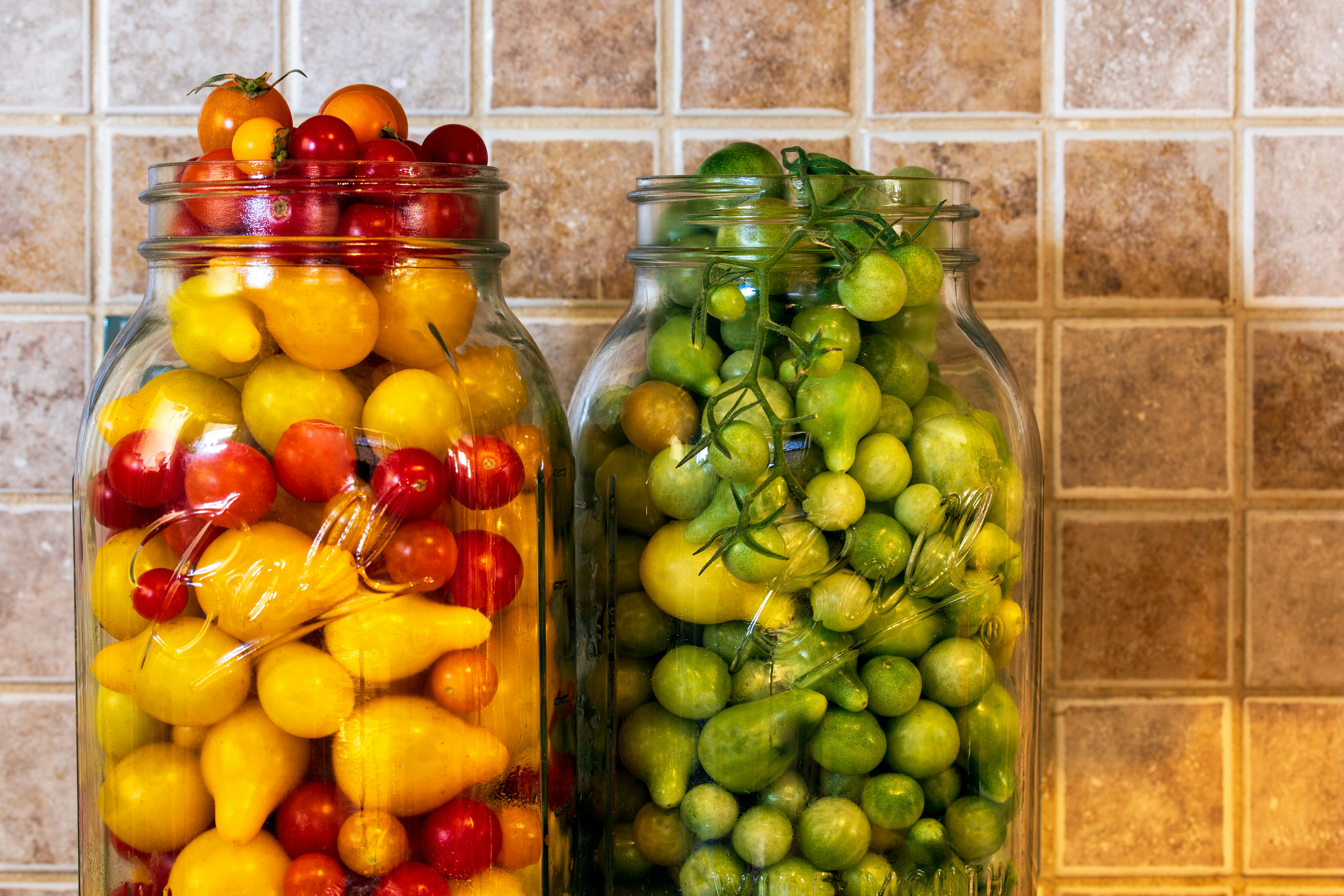 green and red fruit in glass jar