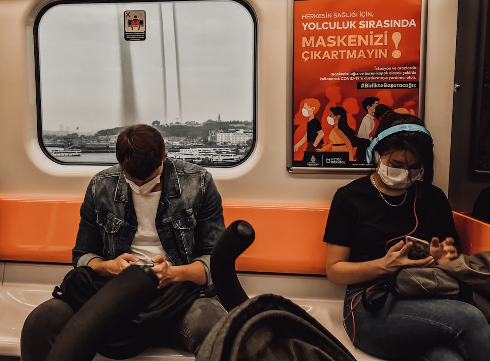 man in black jacket sitting on train seat