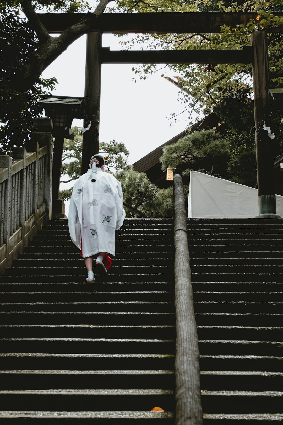 woman in white robe walking on brown wooden staircase