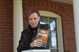 woman in black coat holding book