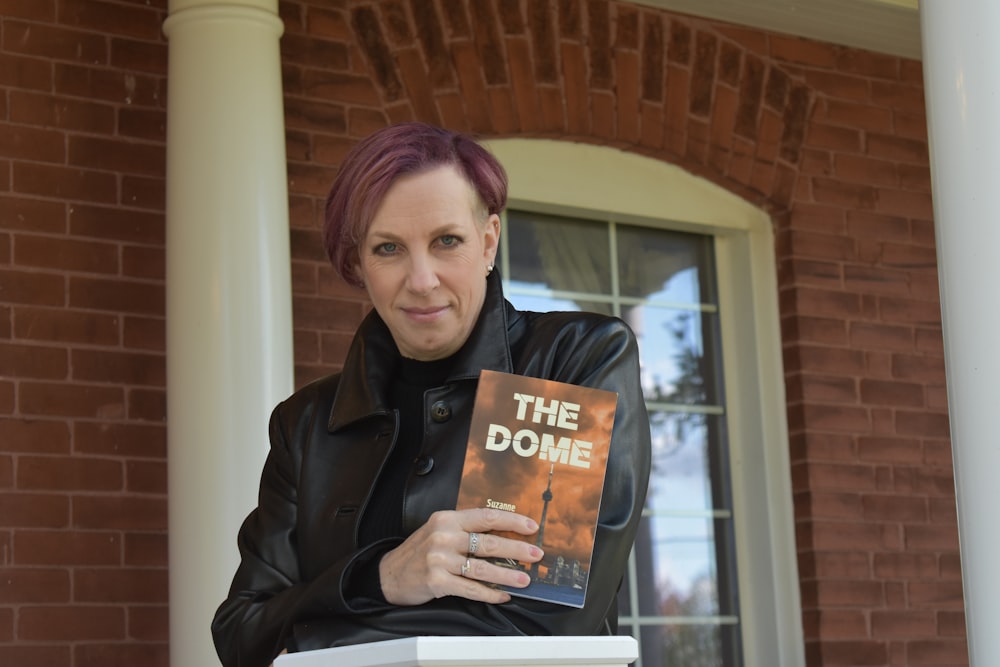 woman in black coat holding book