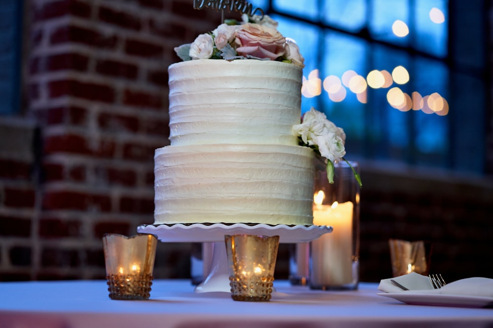 white cake with pink rose on top