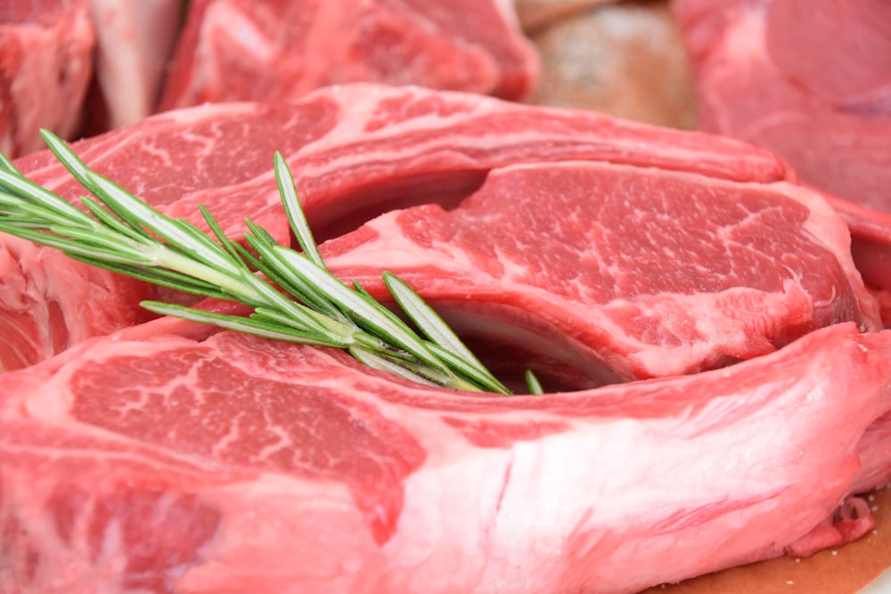 sliced raw meat with green leaves