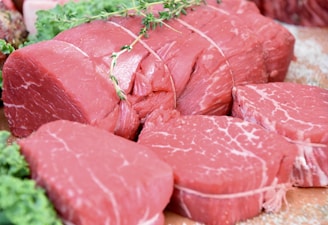 sliced raw meat on brown wooden table