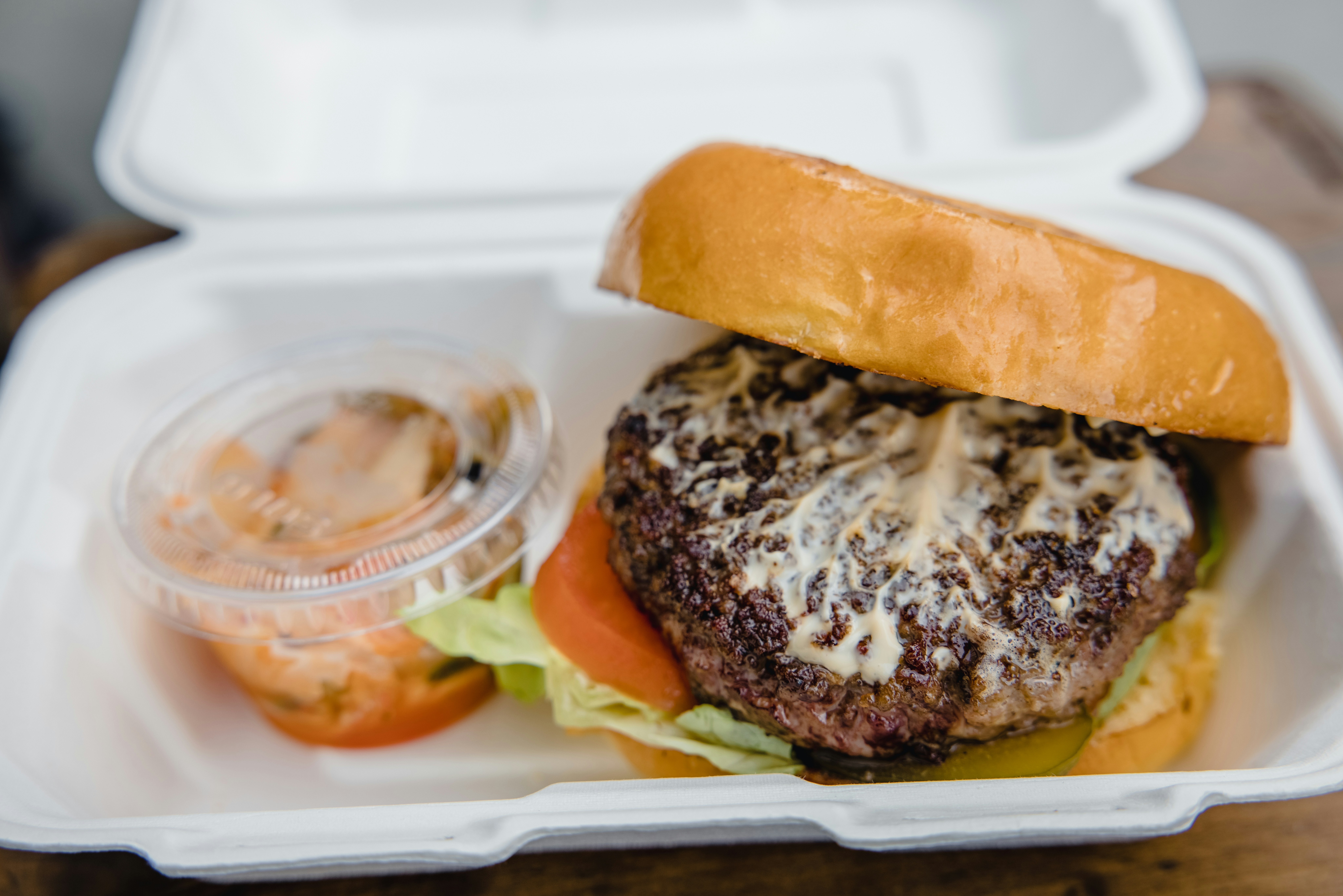 Burger and sauce in a foam takeaway box