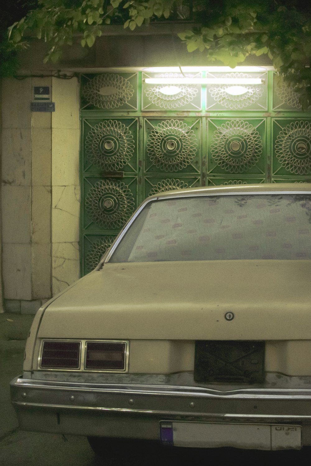 white car parked beside brown brick wall