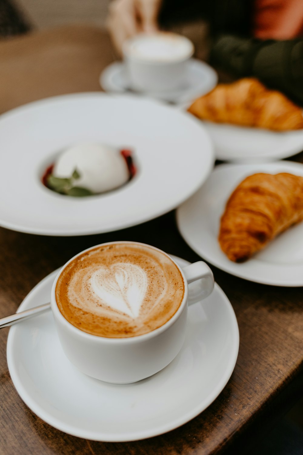 white ceramic cup with saucer and saucer with brown bread