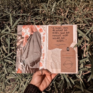 person holding brown and white book