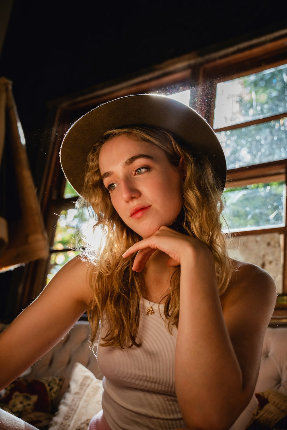 woman in white tank top wearing black fedora hat