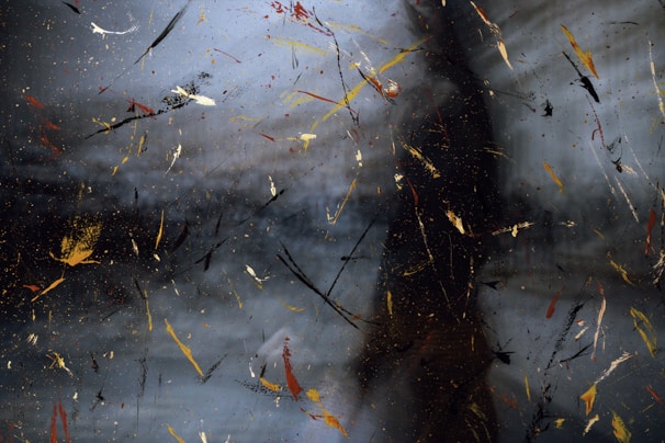 An abstract splash of paint shaped like sound waves on a dark background.