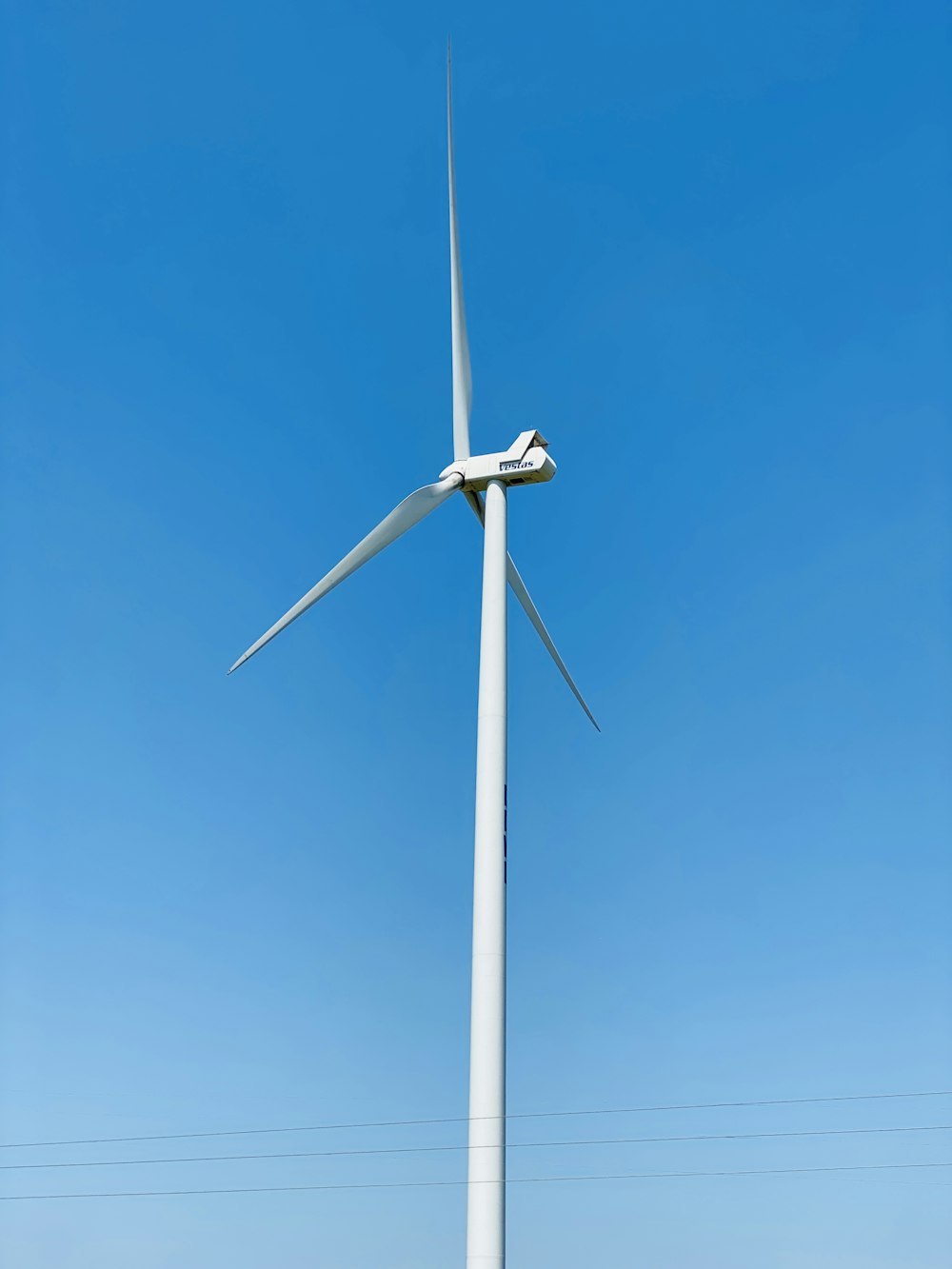 white wind turbine under blue sky during daytime