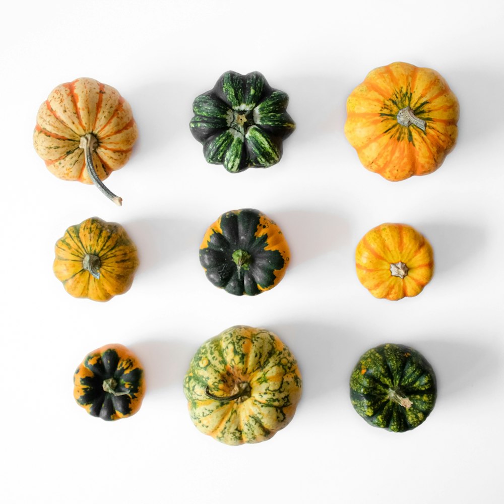 orange and green pumpkins on white surface