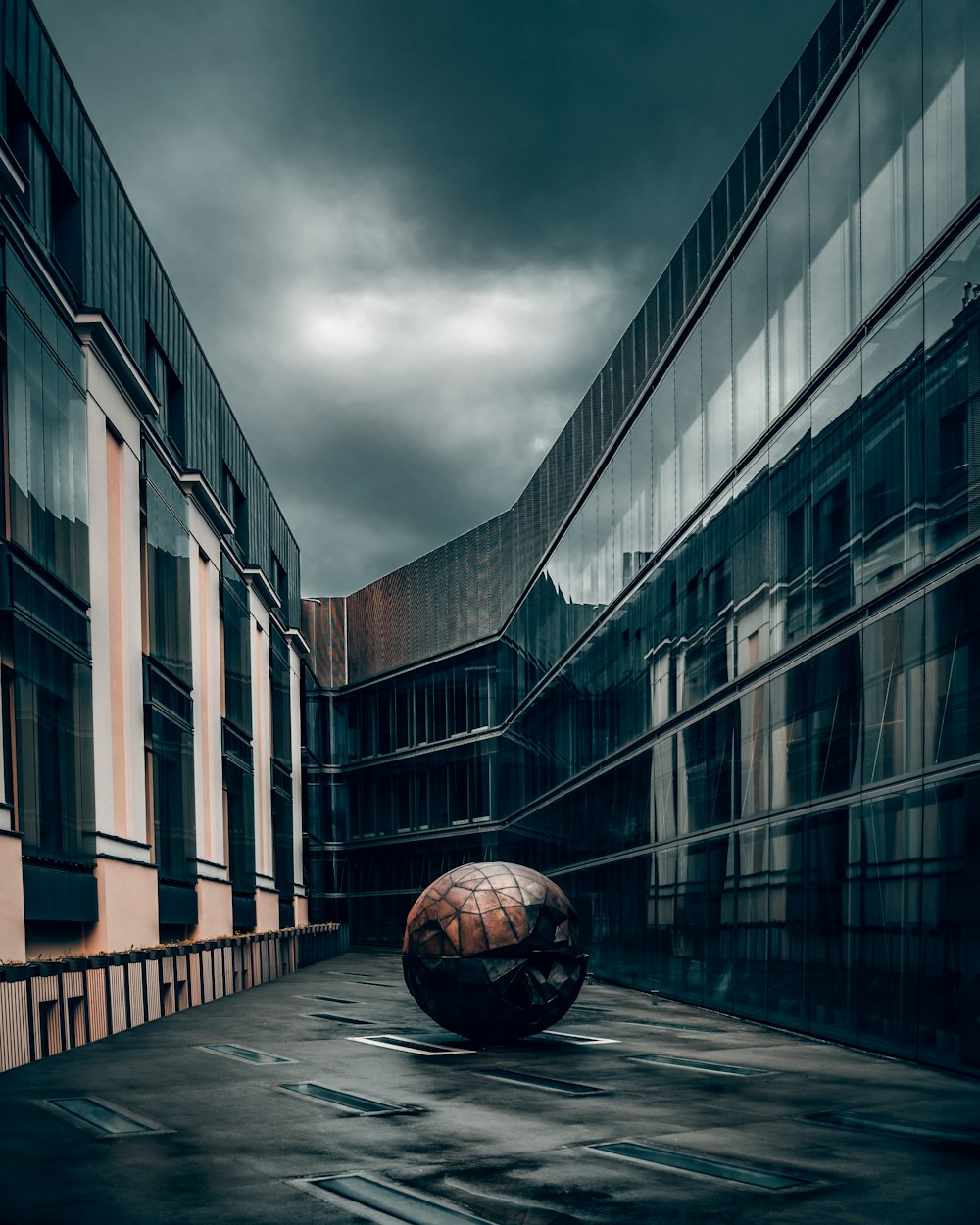 brown and black ball on gray concrete floor near brown concrete building during daytime