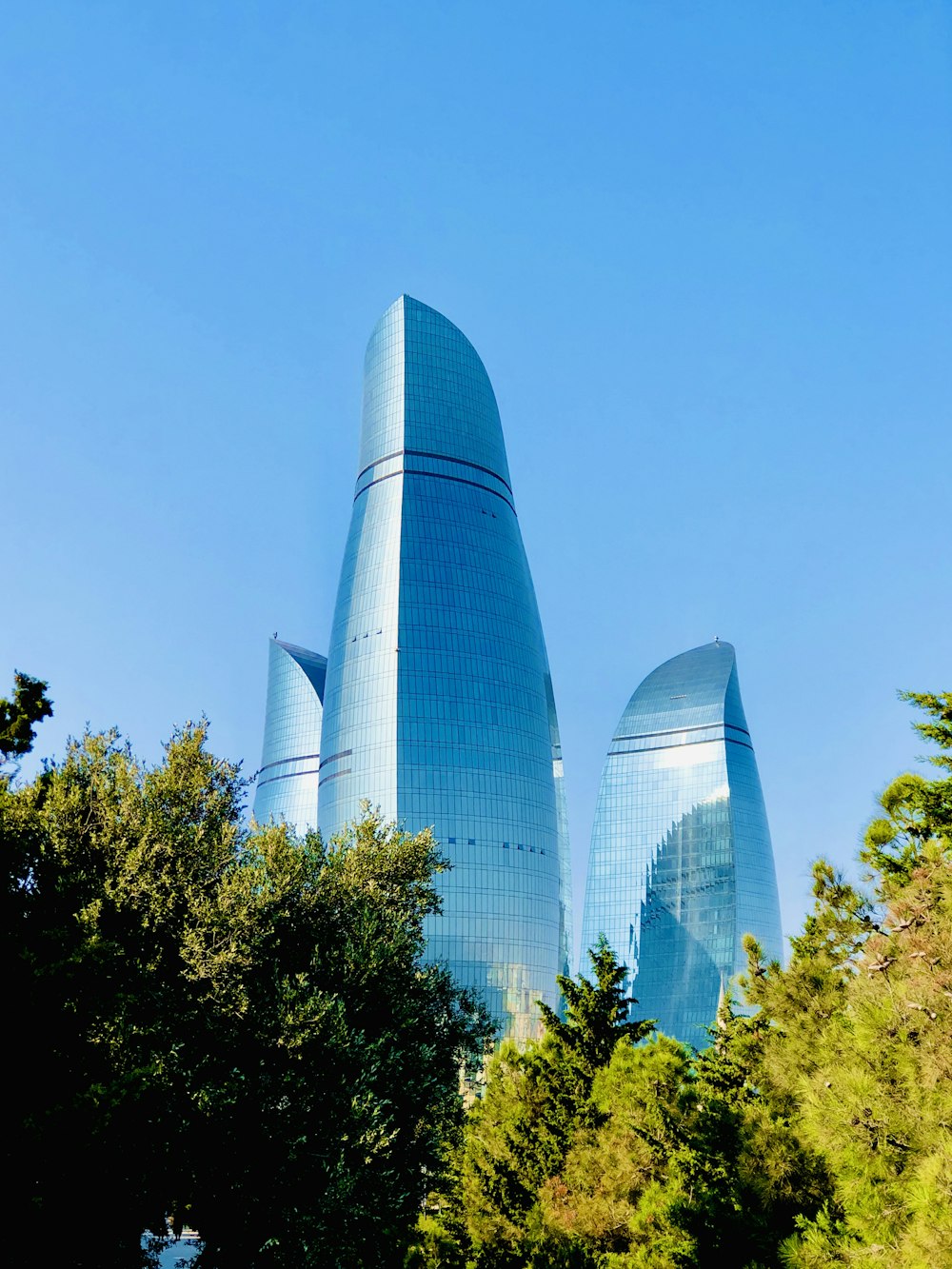 white high rise building near green trees under blue sky during daytime