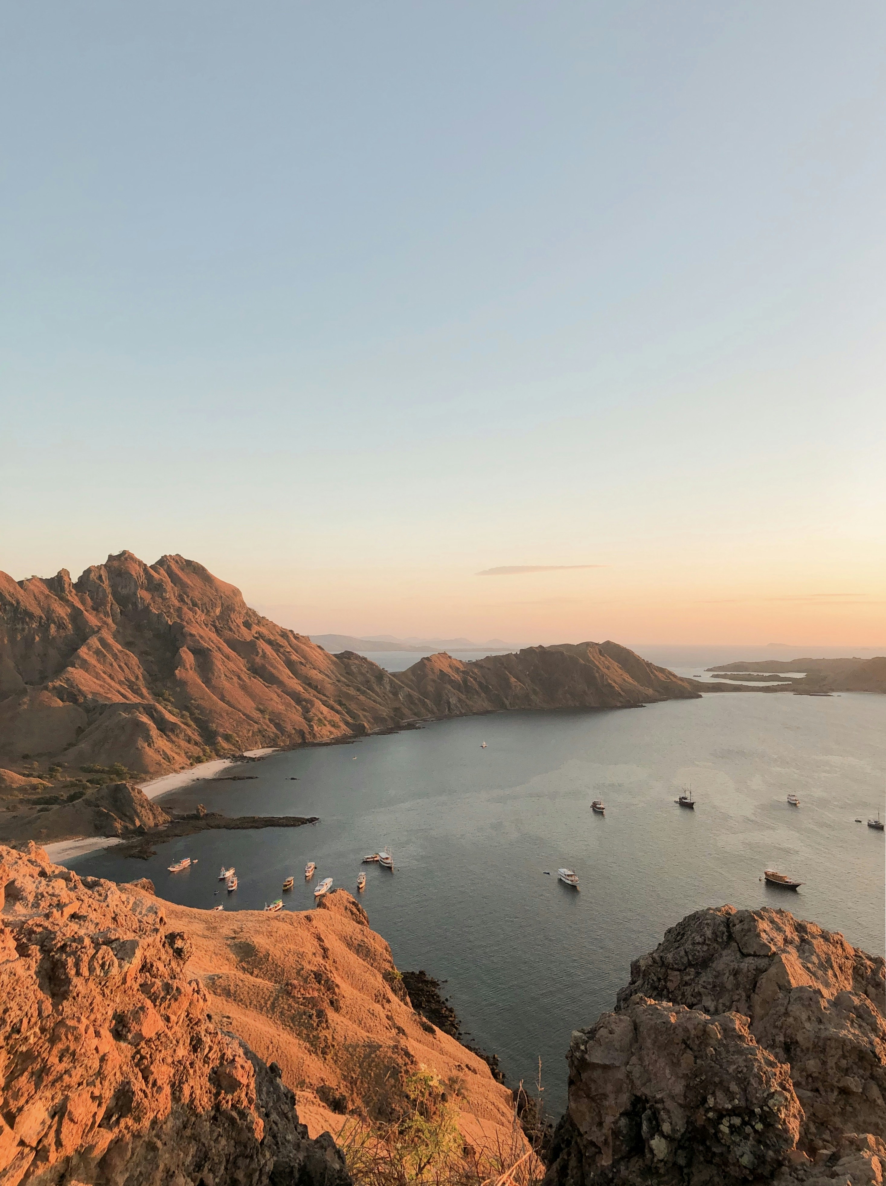 brown rocky mountain near body of water during daytime