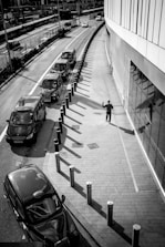 grayscale photo of people walking on sidewalk