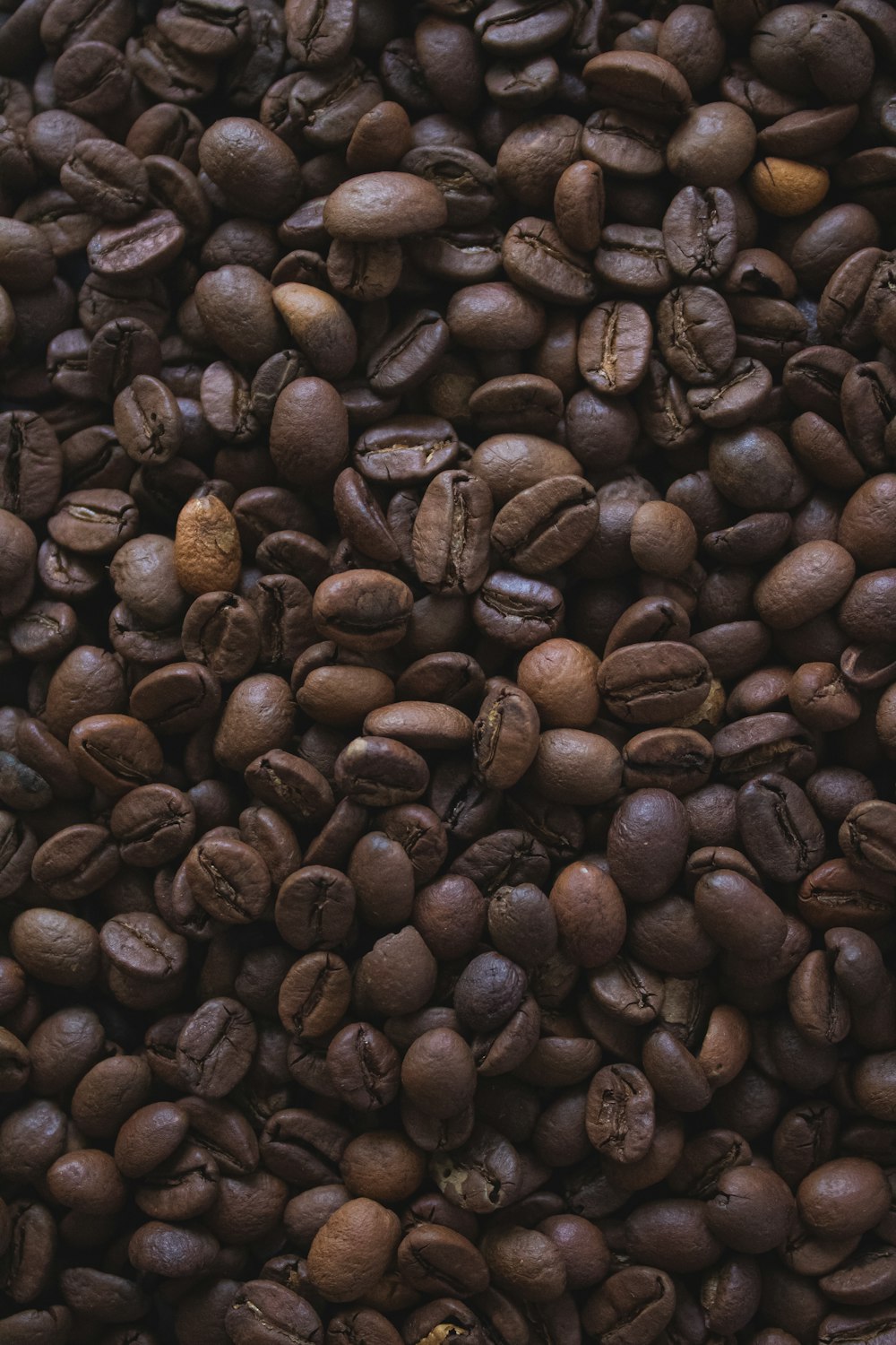 braune Kaffeebohnen auf schwarzer Oberfläche
