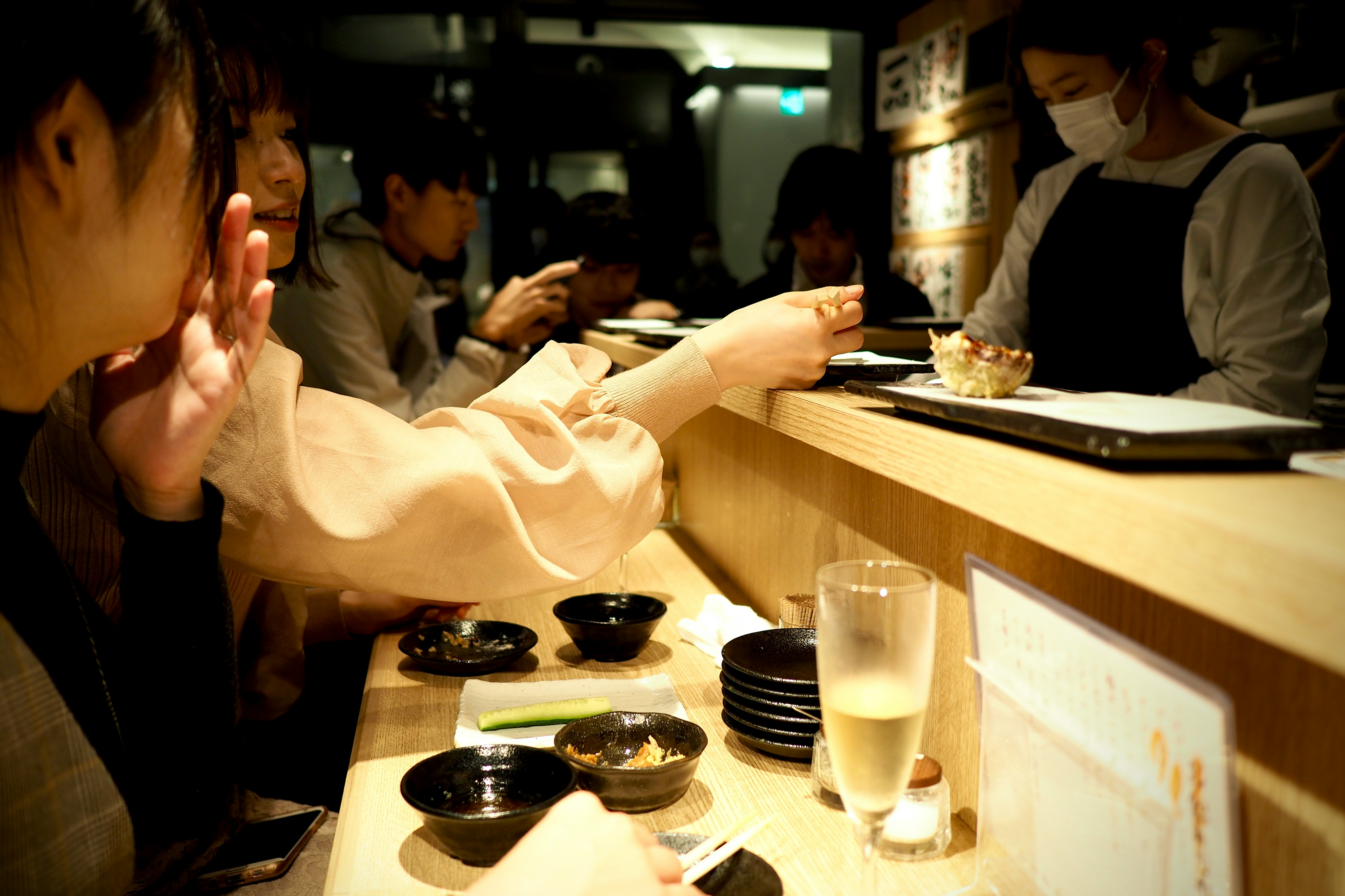 woman in white long sleeve shirt sitting beside table with food