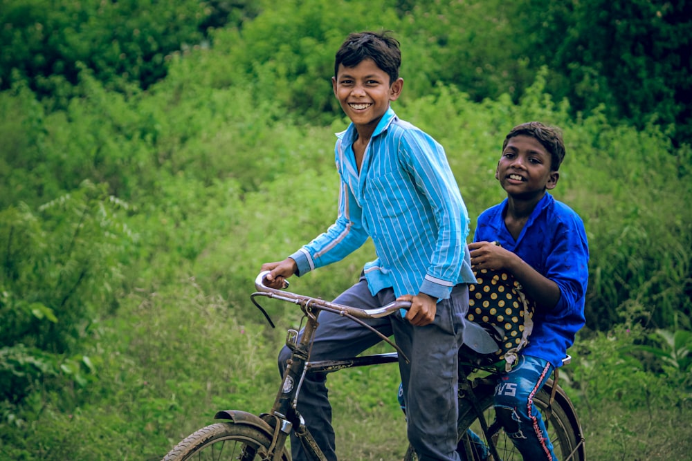 man in blue and white dress shirt riding on black bicycle