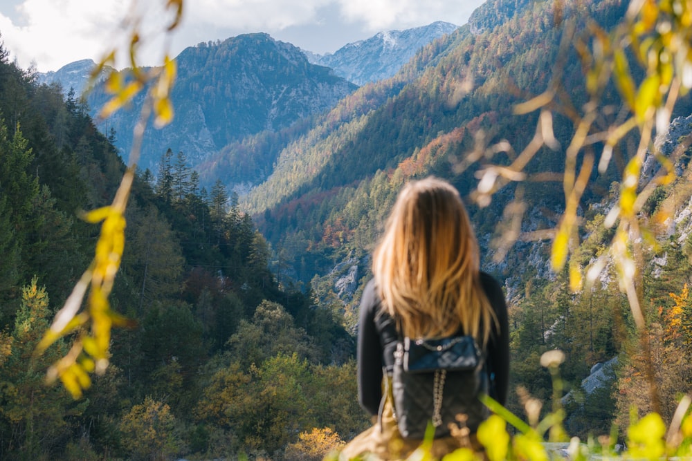 Donna in giacca nera in piedi sul campo di erba verde durante il giorno