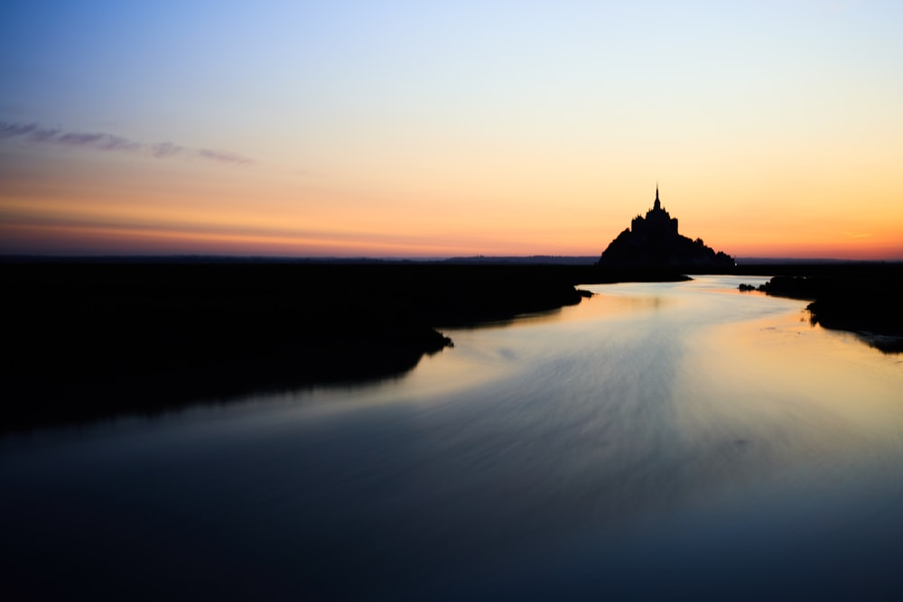 silhouette of building on island during sunset