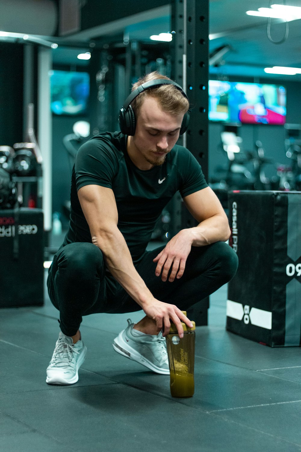 man in black crew neck t-shirt and black pants sitting on brown wooden seat