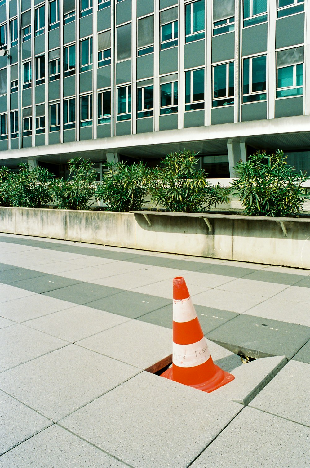 cono di traffico arancione e bianco su pavimento di cemento grigio