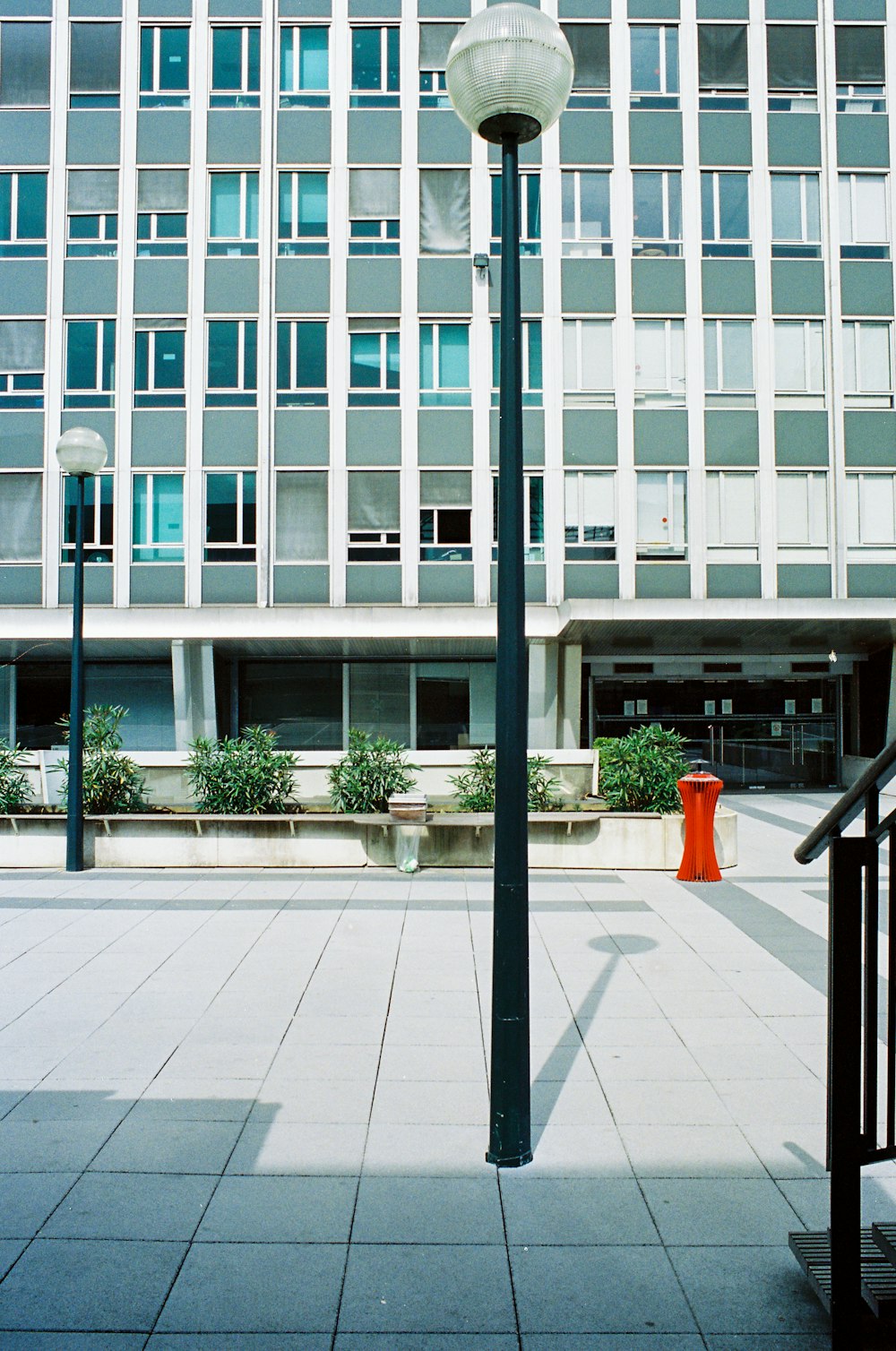 red plastic chair near glass window building during daytime