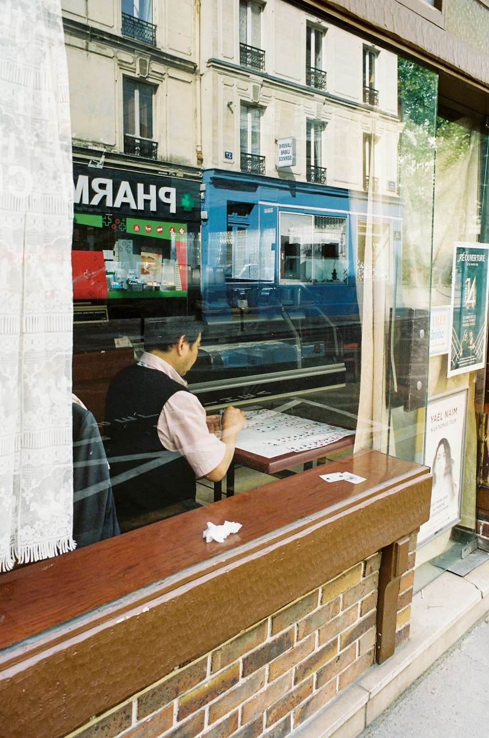 man in black t-shirt sitting at the table using laptop computer