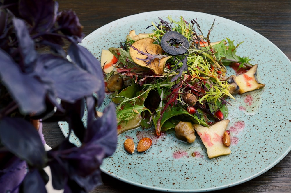 Salade de légumes verts et rouges sur assiette en céramique blanche