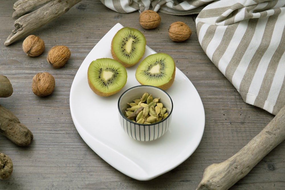 a white plate topped with kiwi fruit and nuts