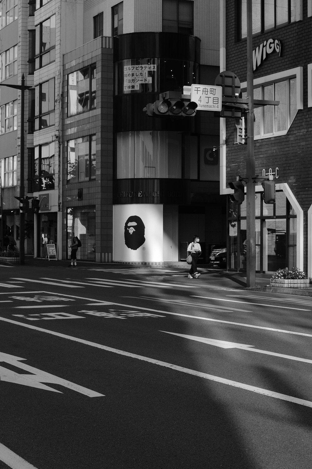 grayscale photo of man riding bicycle on road