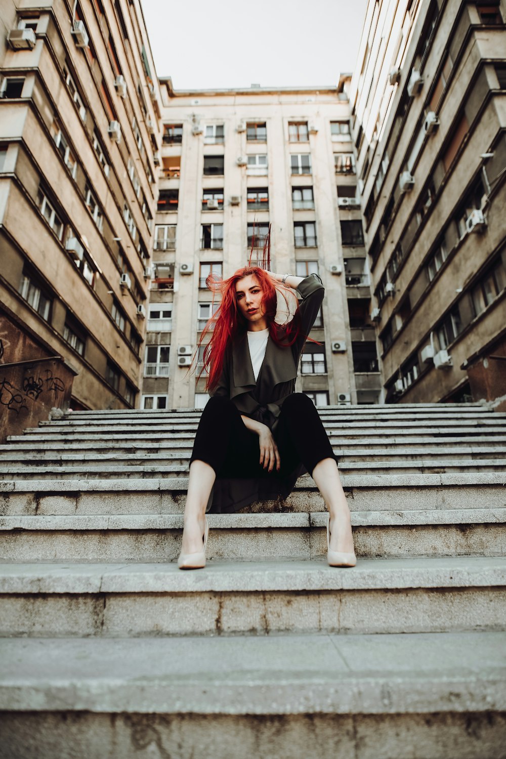 Femme en robe noire assise dans les escaliers