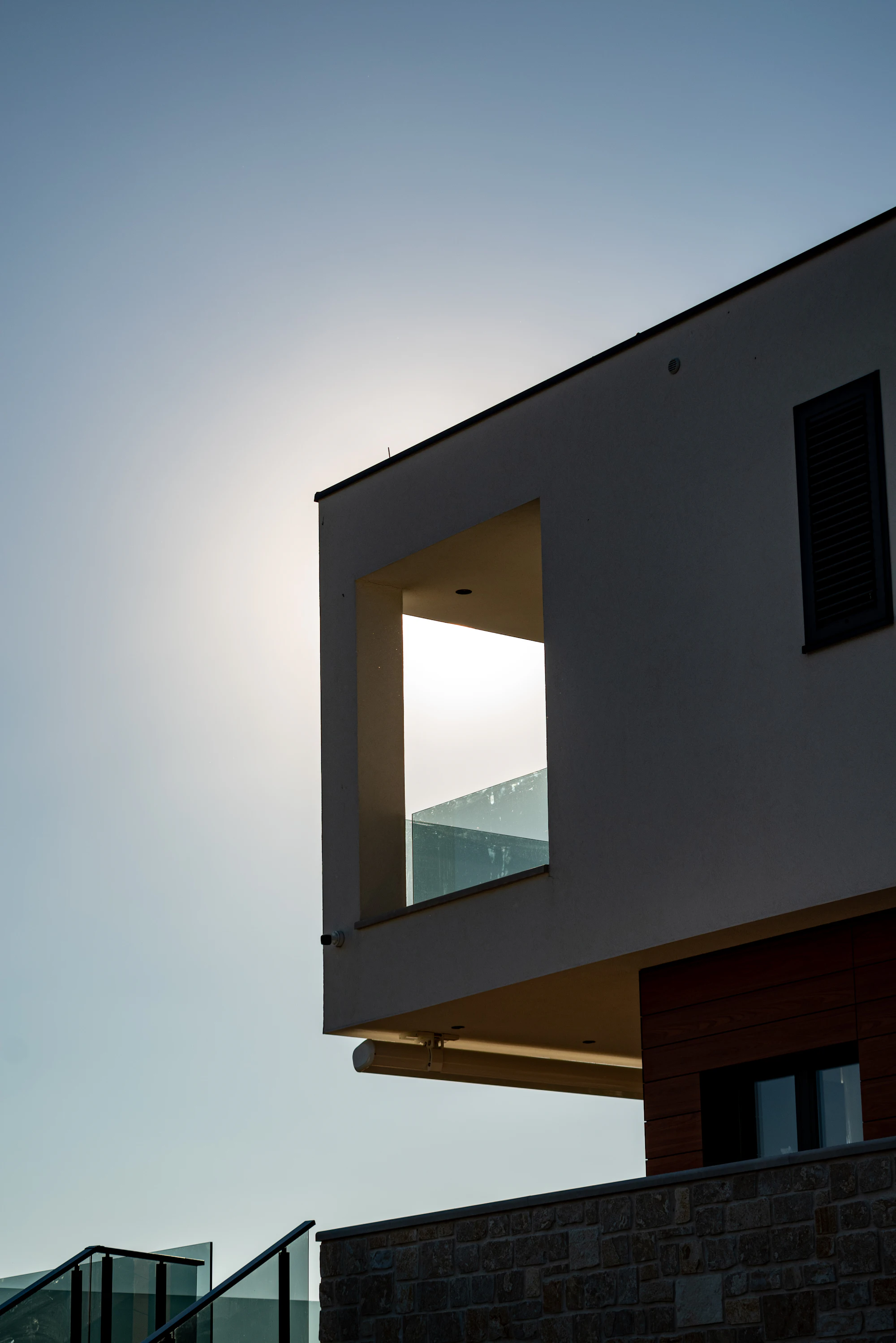 Moderne Hausfassade in der Abendsonne mit grossem, rahmenlosem Fensterausschnitt