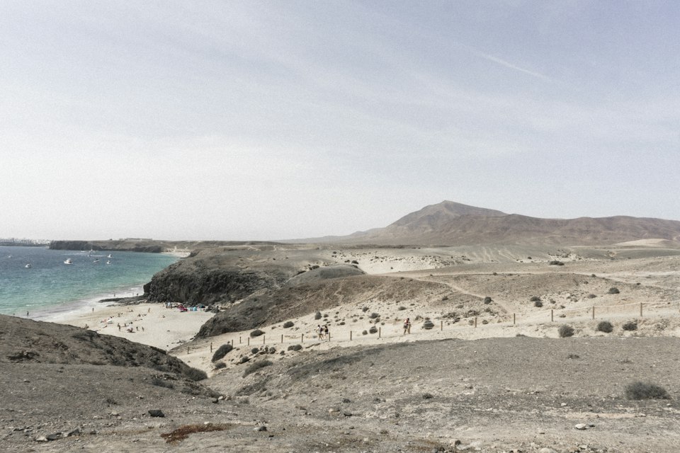 The golden sand and sheltered cove of Playa del Papagayo framed by cliffs, Lanzarote