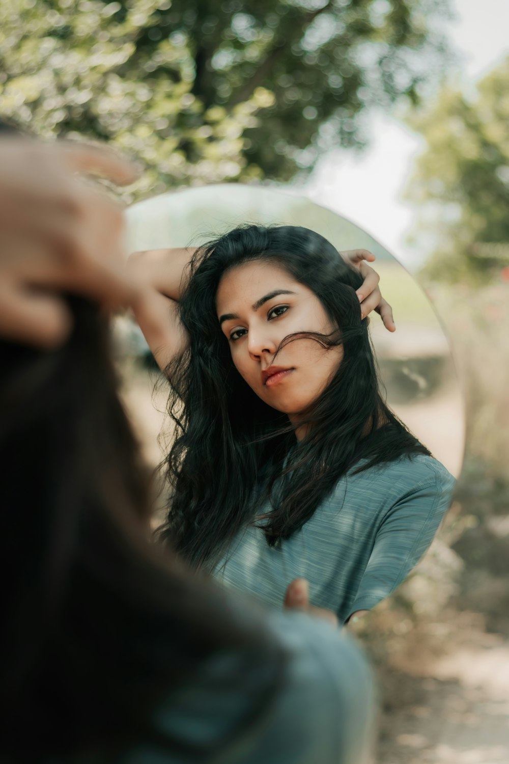 woman in black long sleeve shirt holding her hair