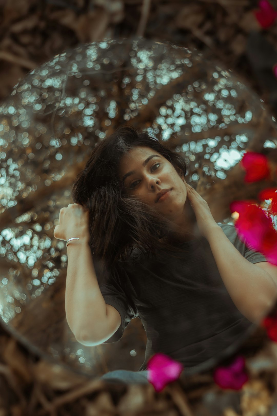 woman in white tank top standing under brown tree with string lights