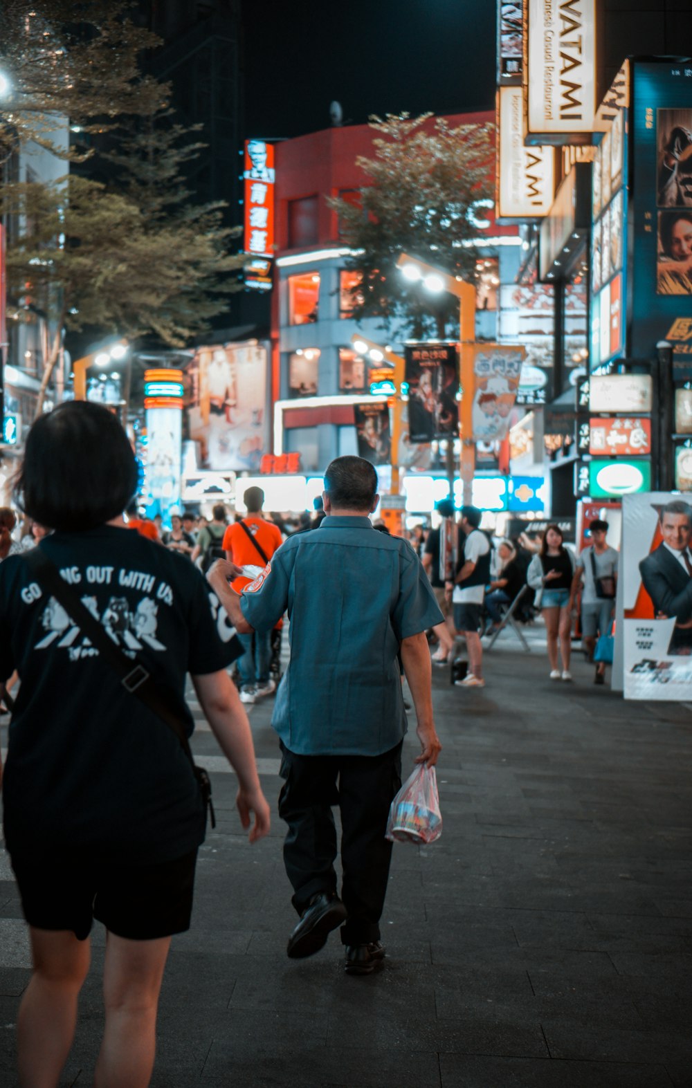 persone che camminano per strada durante la notte