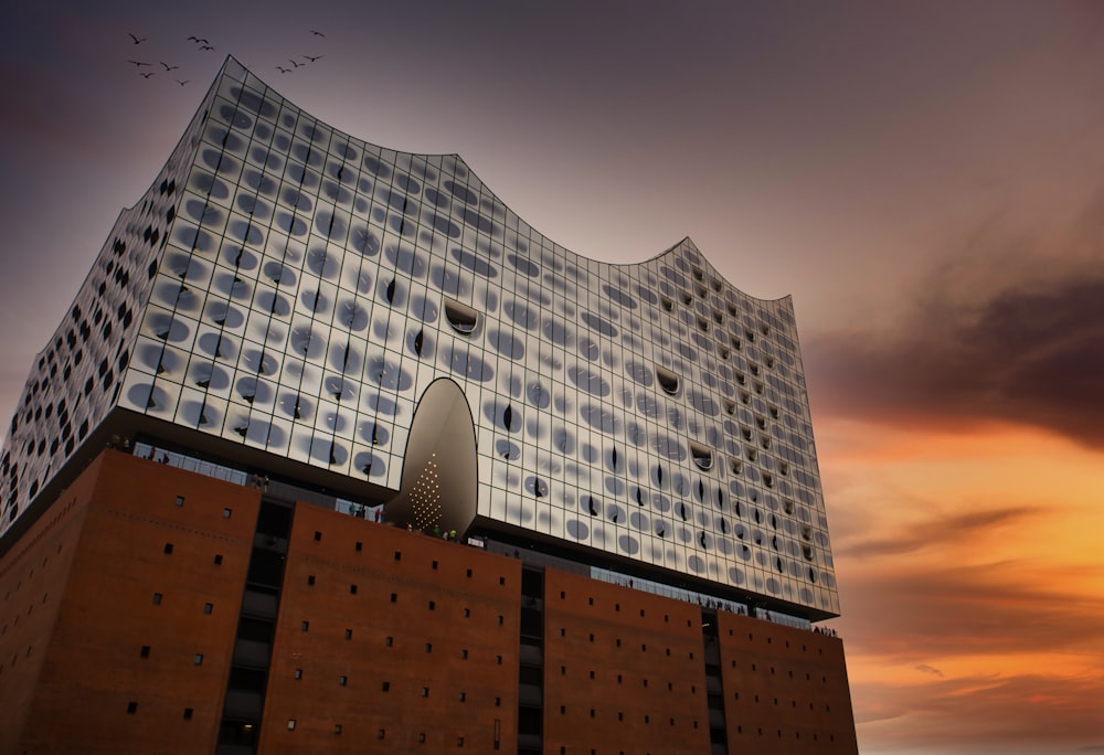 Graues Betongebäude unter orangefarbenem Himmel