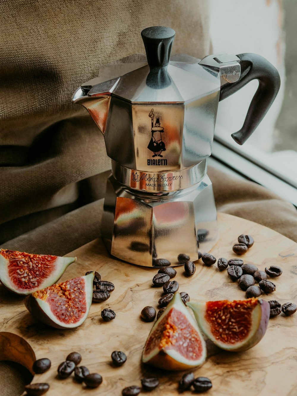 silver and black coffee pot on white textile