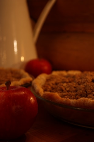 A close-up of a freshly baked apple pie cooling on a windowsill, with a soft afternoon light.