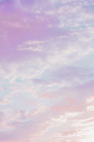 Soft pastel blue and white anime-inspired sky background with gentle clouds and glowing light.