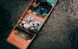 people in blue and black shirt riding on boat during daytime