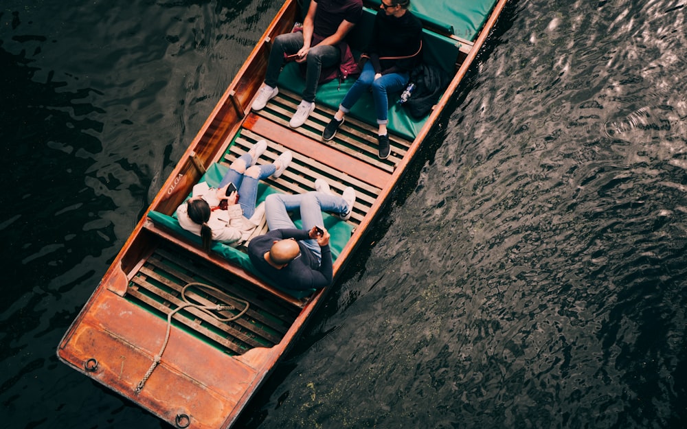 Personas con camisa azul y negra montando en bote durante el día