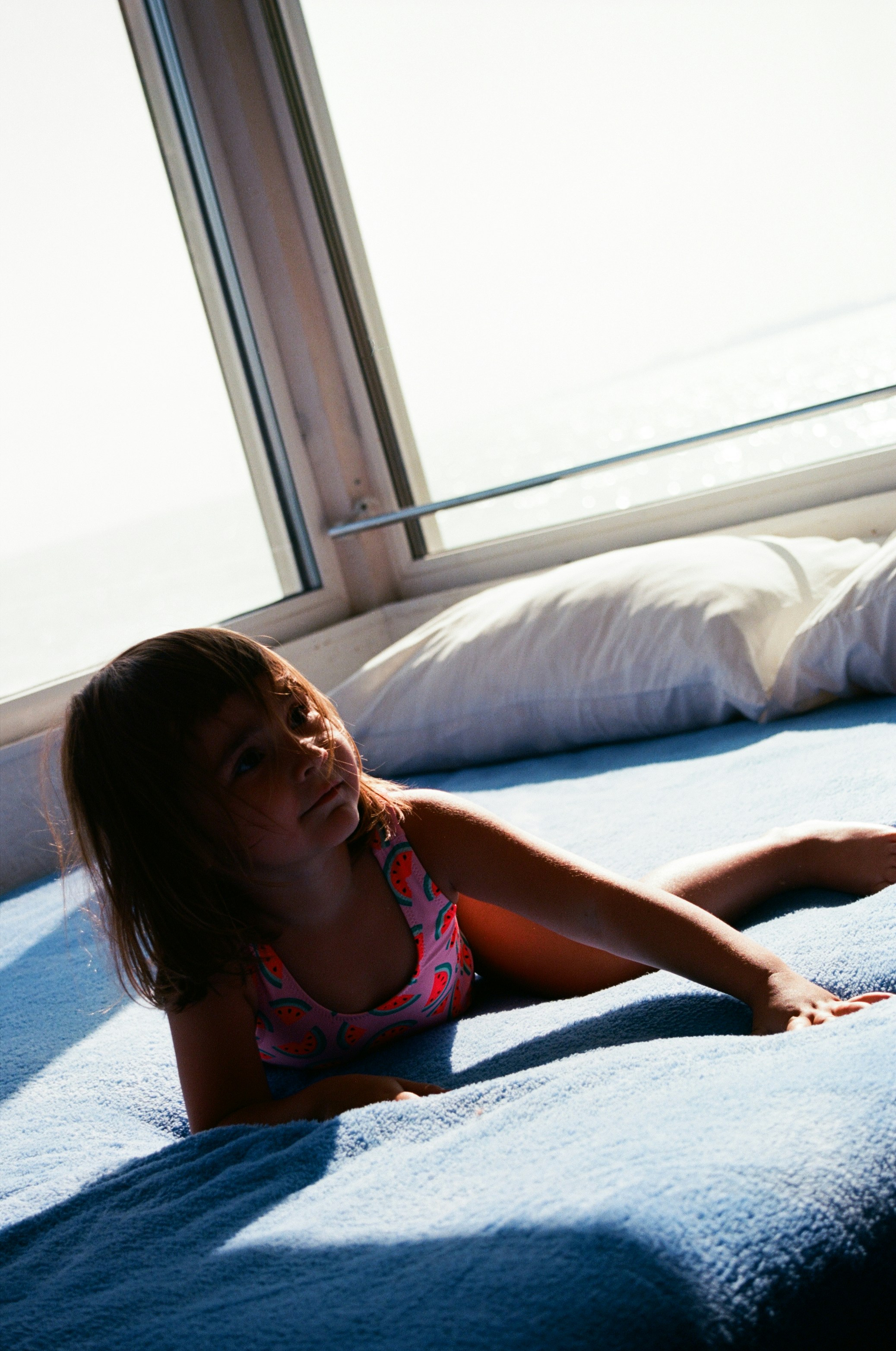 girl in pink and white floral bikini lying on bed