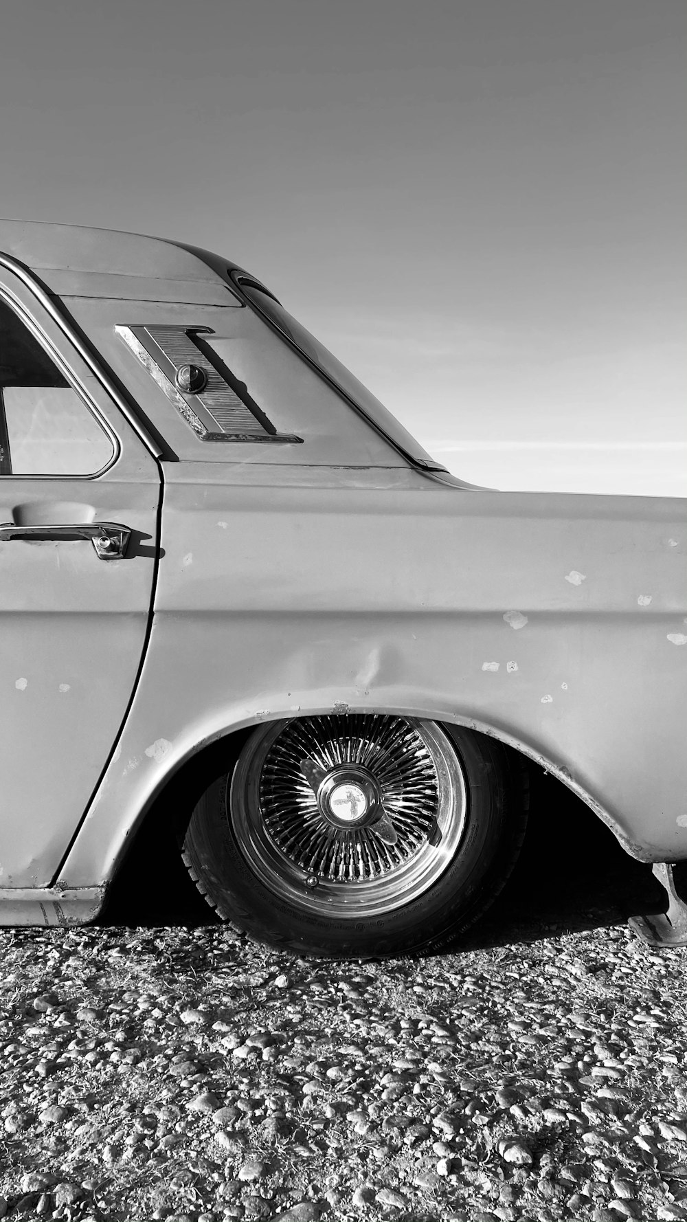 grayscale photo of car on black soil