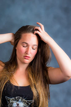 woman in black tank top holding her hair